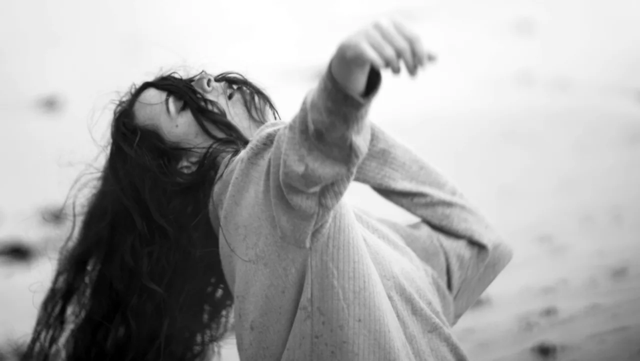 Fotograma de «Confused»: fotografía en blanco y negro de una mujer que baila con el pelo al viento.