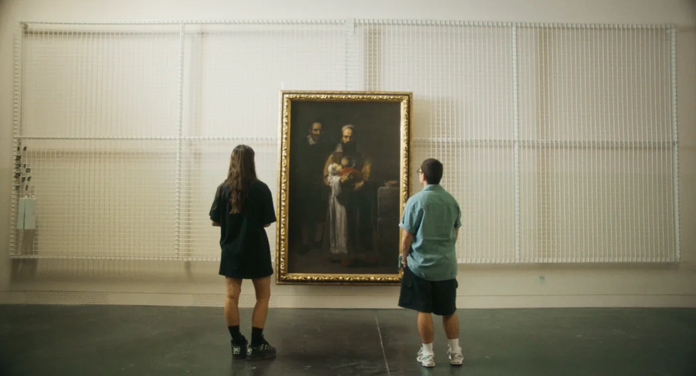 Fotograma de «Este cuerpo mío»: dos personas, de espaldas, contemplan un cuadro en una sala de museo.